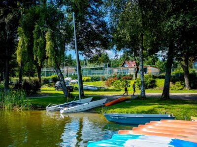 Łódki i kajaki nad jeziorem. Wakacje i wypoczynek na wodzie.