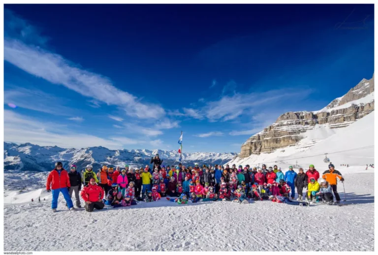 Duża grupa narciarzy i snowboardzistów na tle gór. Zimowy krajobraz.