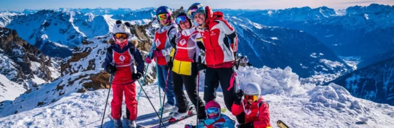 Rodzina na nartach w Alpach. Radosne dzieci i dorośli cieszą się zimowymi sportami na ośnieżonych szczytach.