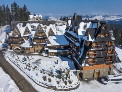 Drewniany hotel w górach zimą. Drewniana architektura, śnieg, góry.