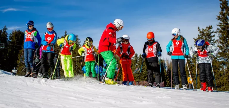 Dzieci na nartach w górach. Nauka jazdy na nartach dla najmłodszych.