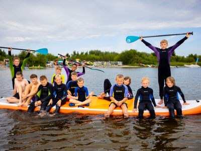 Dzieci na desce SUP, zabawa na wodzie, lato, sport, aktywność.