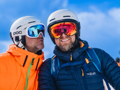 Dwóch narciarzy w kaskach i goglach, gotowych na stok.