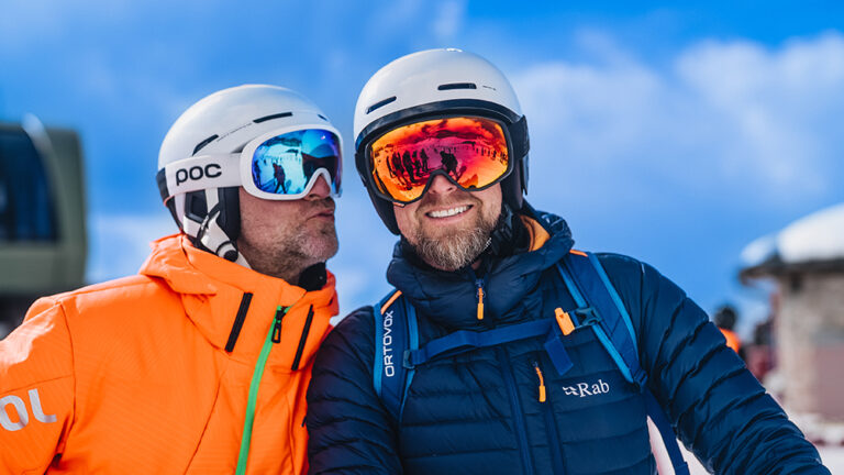 Dwóch narciarzy w kaskach i goglach, gotowych na stok.