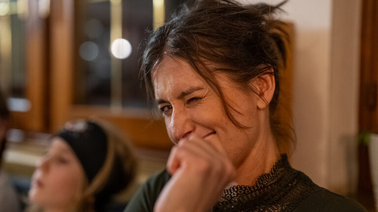 Kobieta mruga i uśmiecha się.