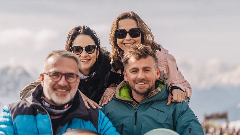 Uśmiechnięci ludzie w górach. Przyjaciele na stoku.