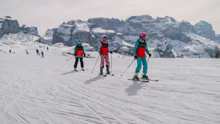 Dzieci na nartach w Dolomitach. Zimowy sport i aktywne wakacje.