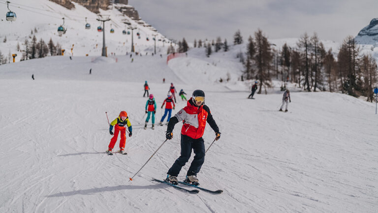 Narciarze na stoku: nauka jazdy na nartach, wyciągi, góry, zimowy sport.