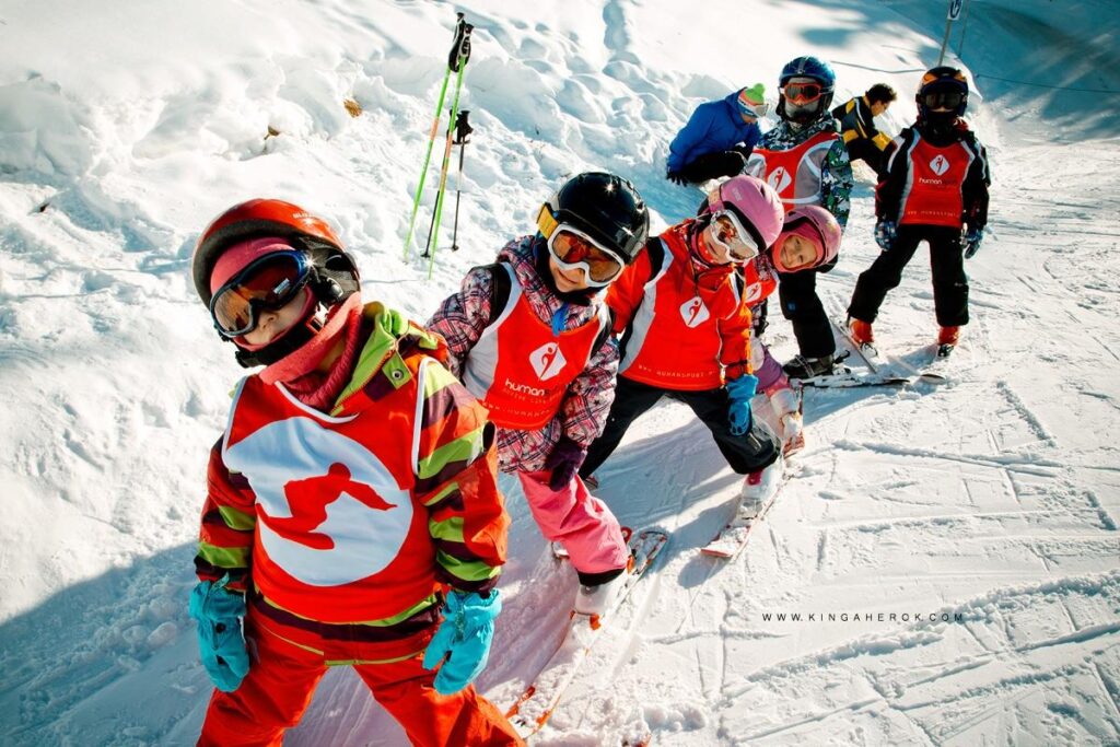 Dzieci na nartach w słoneczny dzień. Nauka jazdy na nartach dla najmłodszych.